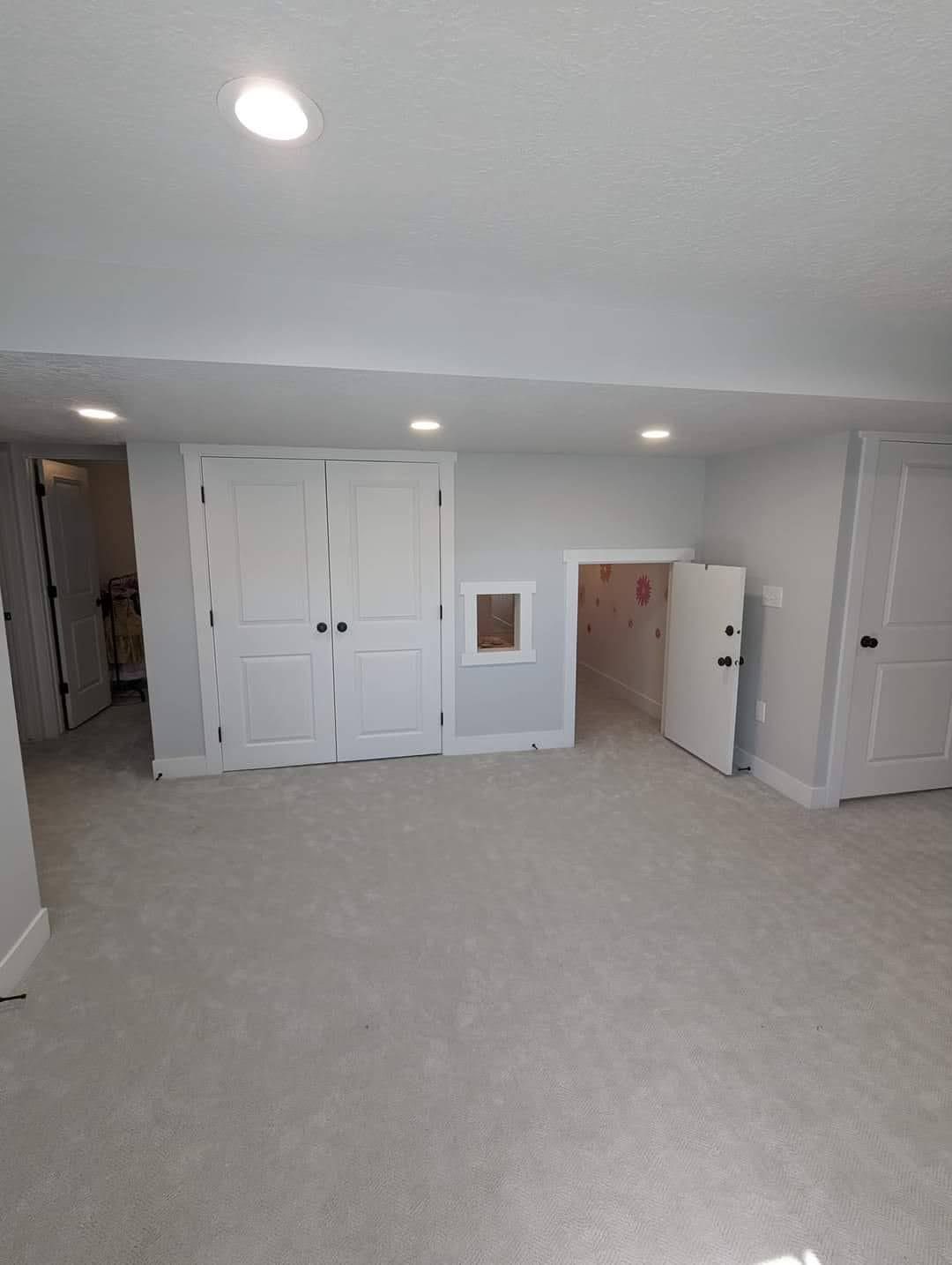 There is a playhouse in the corner of the room.