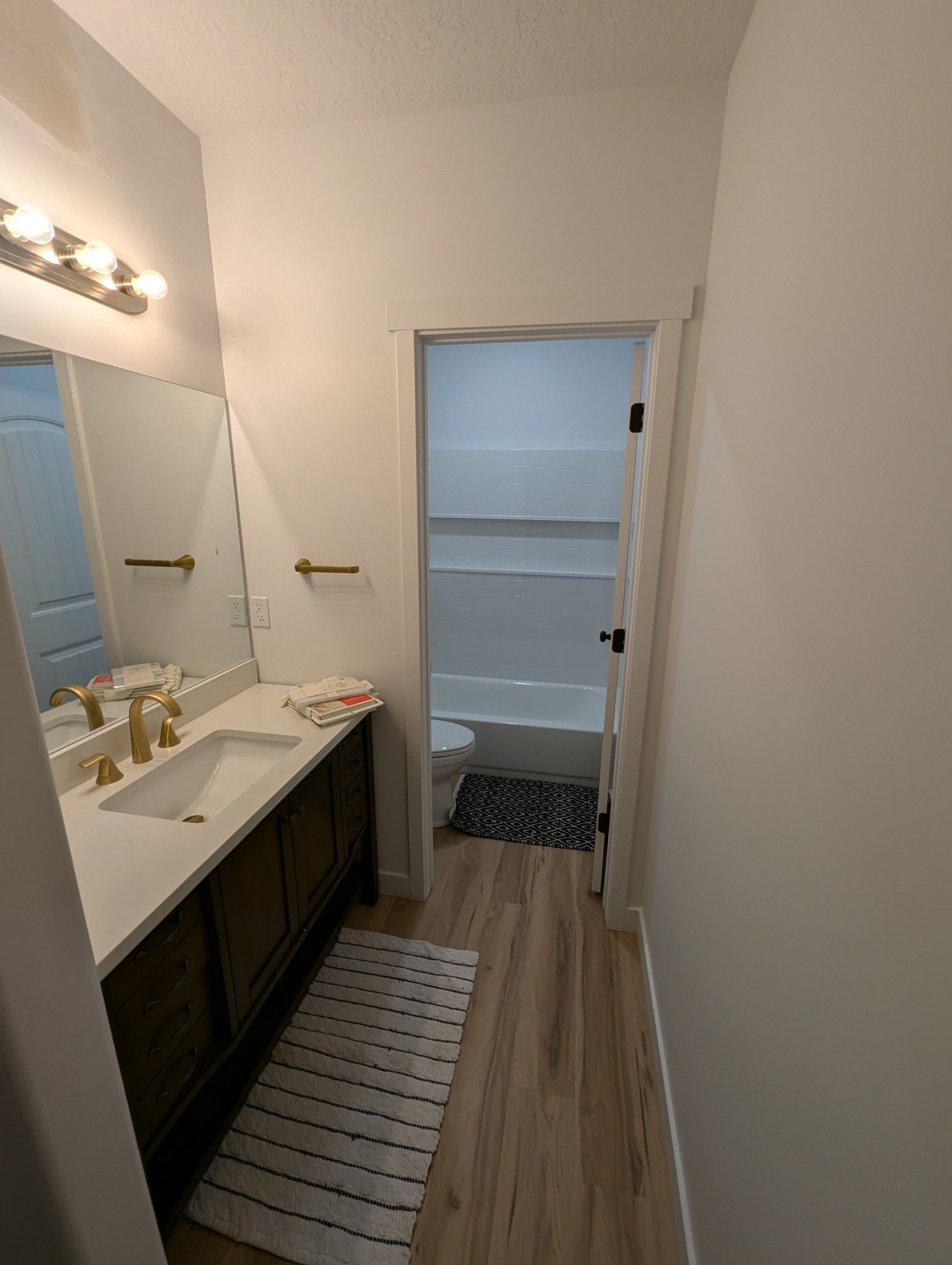A bathroom with a sink , mirror , and bathtub.