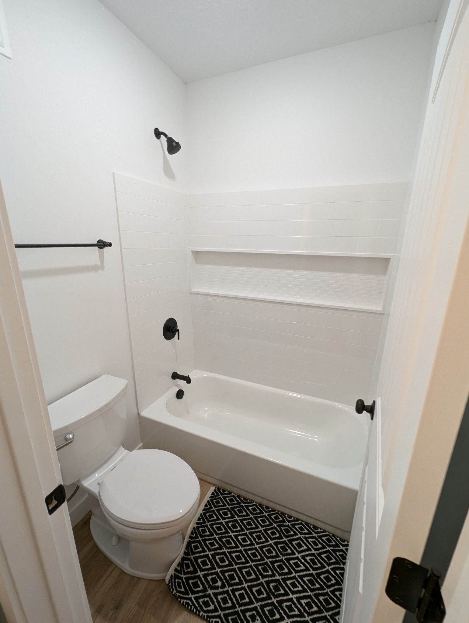 A bathroom with a toilet , bathtub and shower.