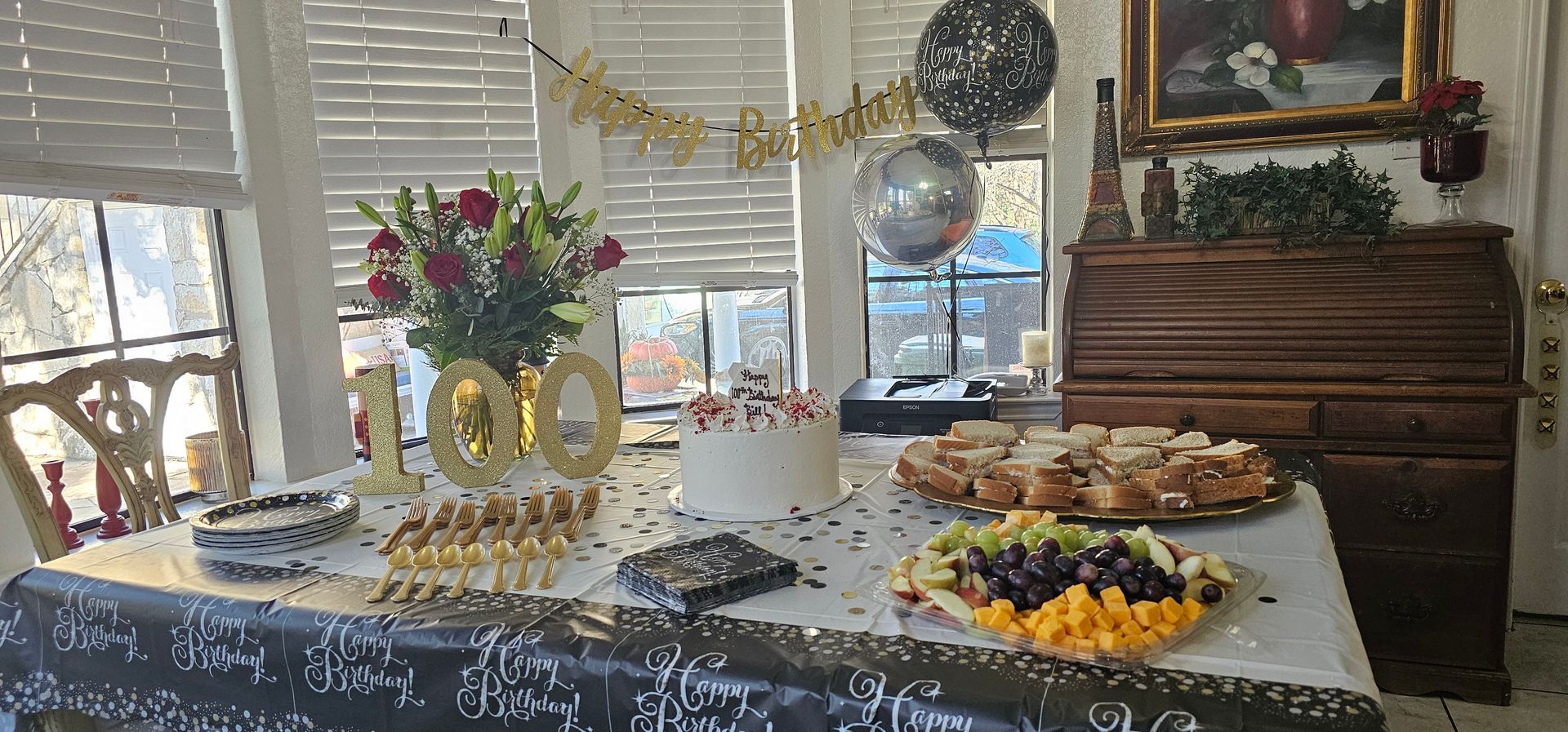 A 100th birthday party table decorated with a 