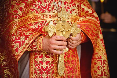 priest holding a cross