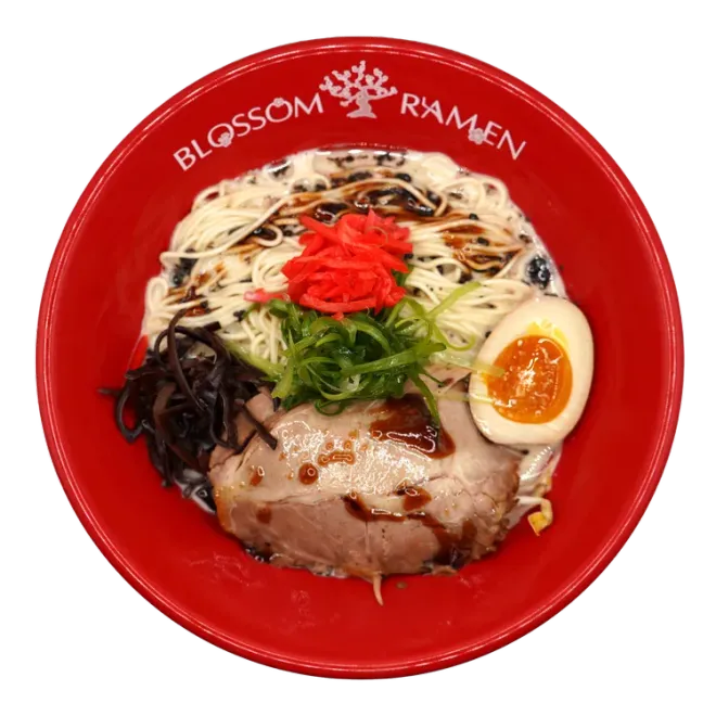 Red ramen bowl with pork, egg, noodles, seaweed, greens, and red garnish from Blossom Ramen.