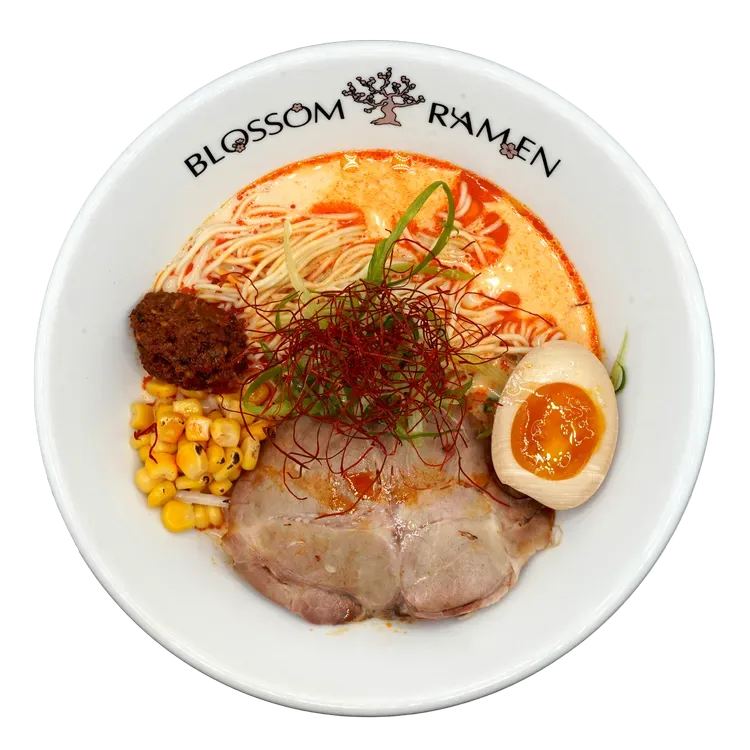 Ramen bowl with broth, noodles, pork, corn, egg, and chili garnish at Blossom Ramen