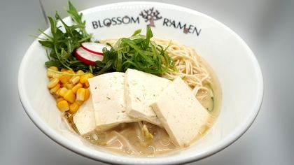 Ramen bowl with tofu, corn, sprouts, radish, and greens at Blossom Ramen