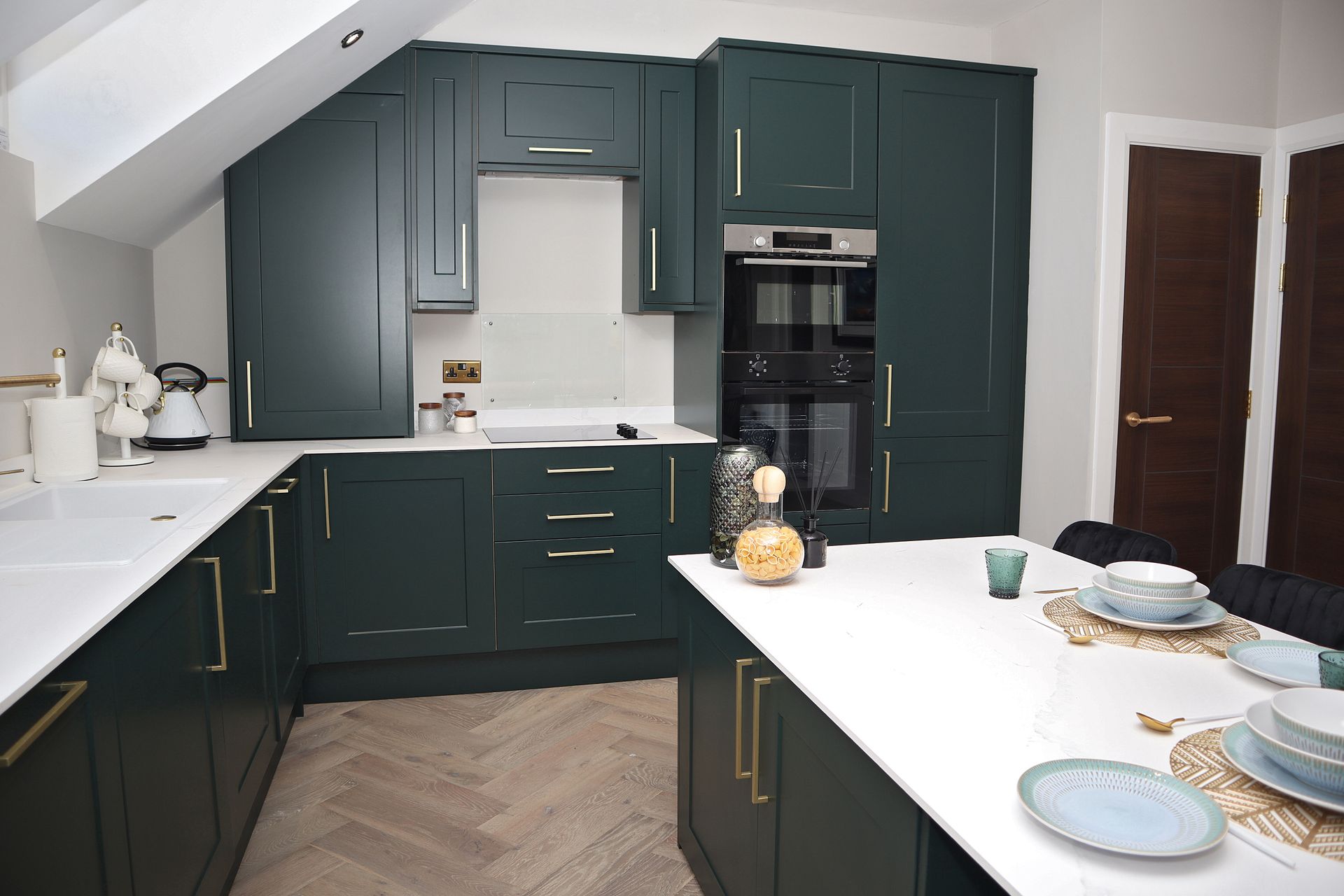 A kitchen with green cabinets and white counter tops