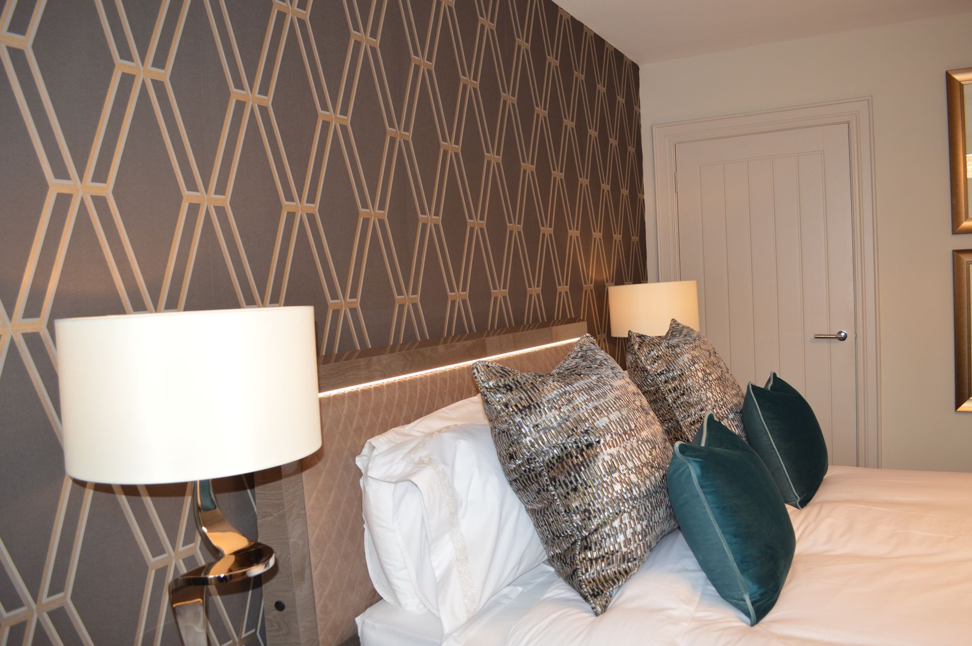 A bed with pillows and lamps in a bedroom