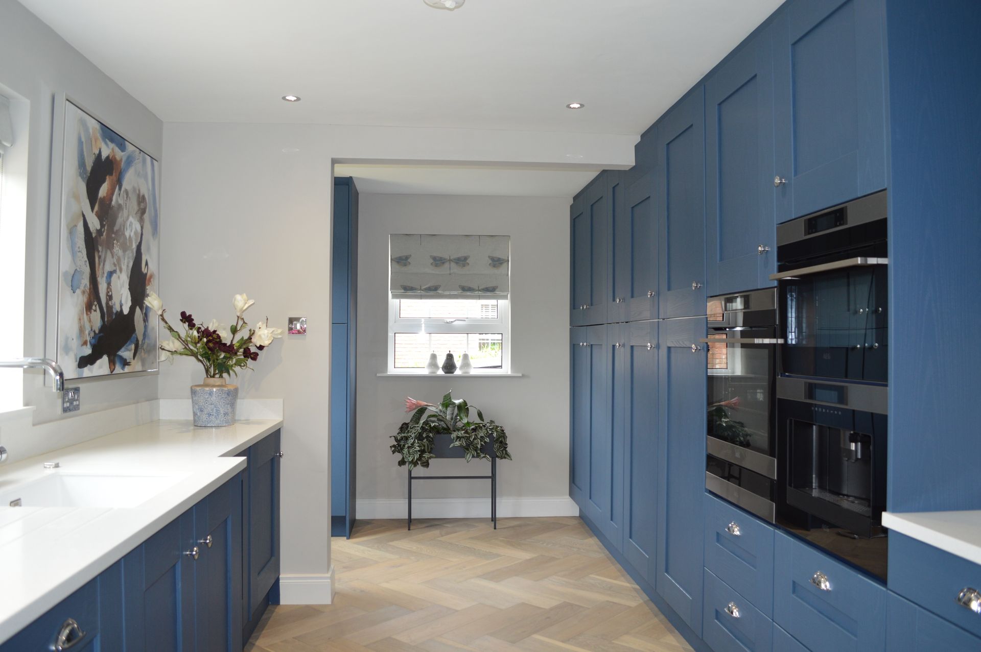 A kitchen with blue cabinets and stainless steel appliances.