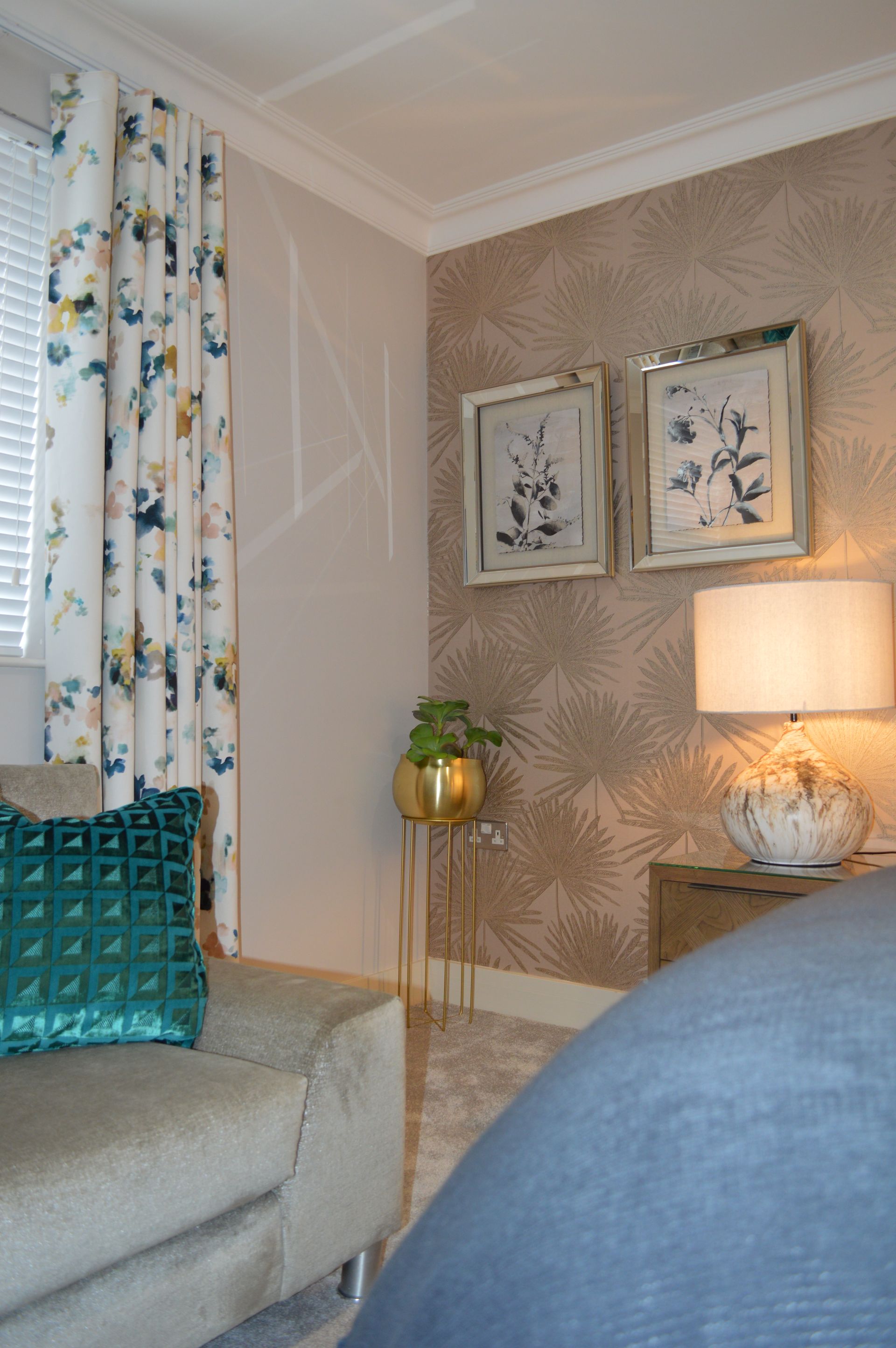 A living room with a couch , two lamps , and two pictures on the wall.