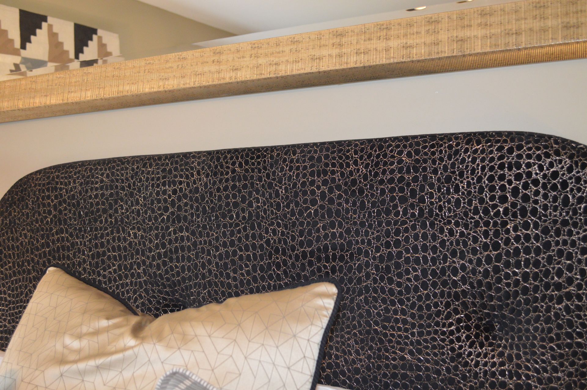 A bed with a leopard print headboard and pillows on it