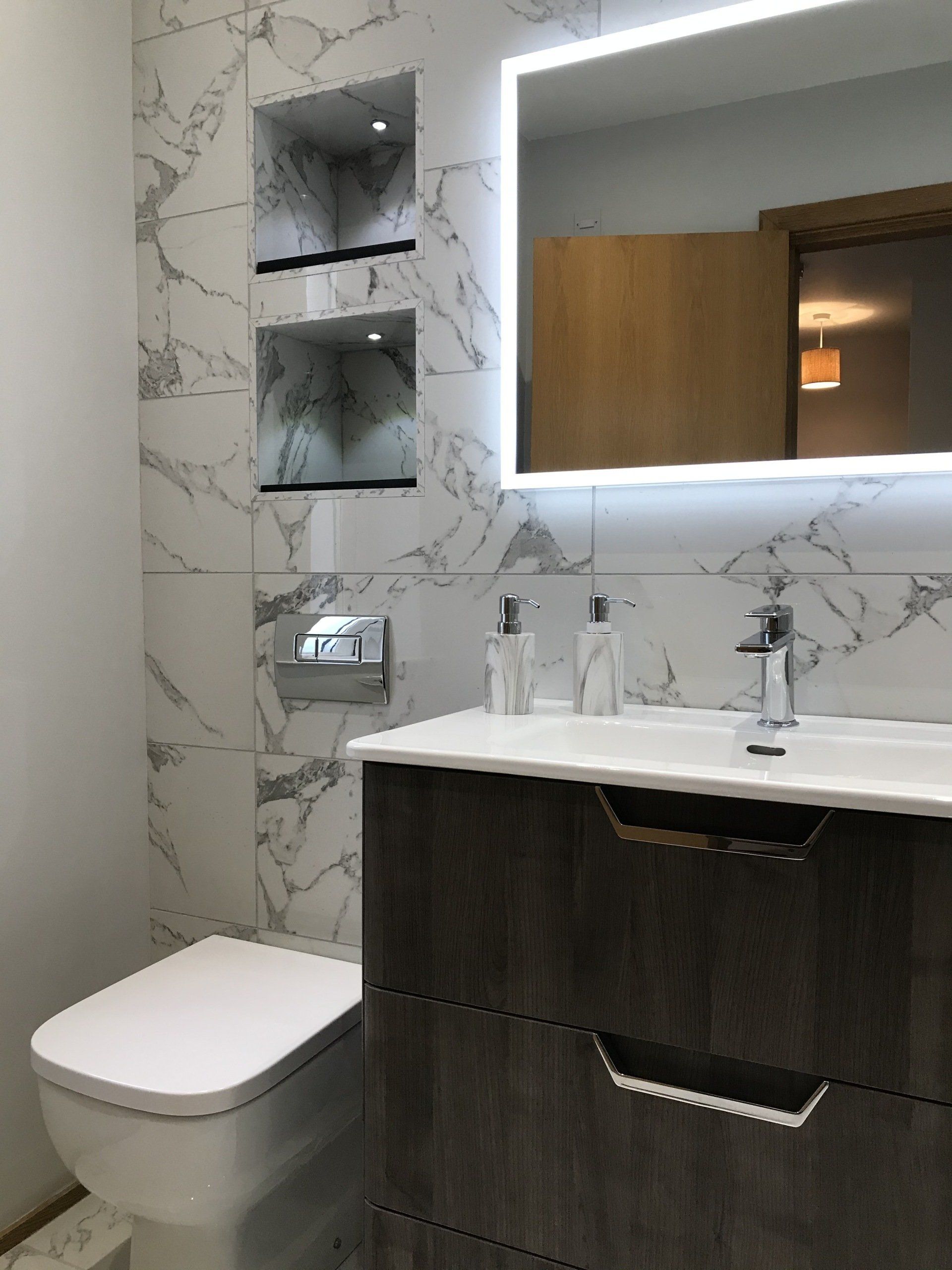 A bathroom with a toilet a sink and a mirror