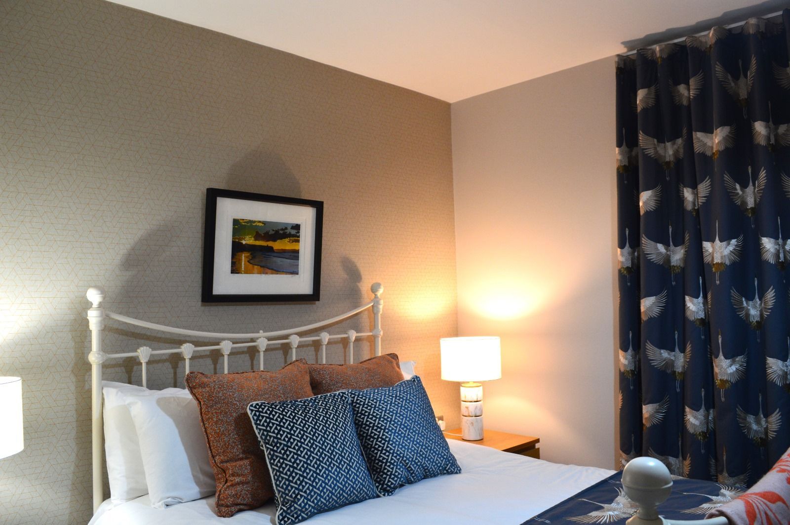 A bedroom with a bed and a picture on the wall