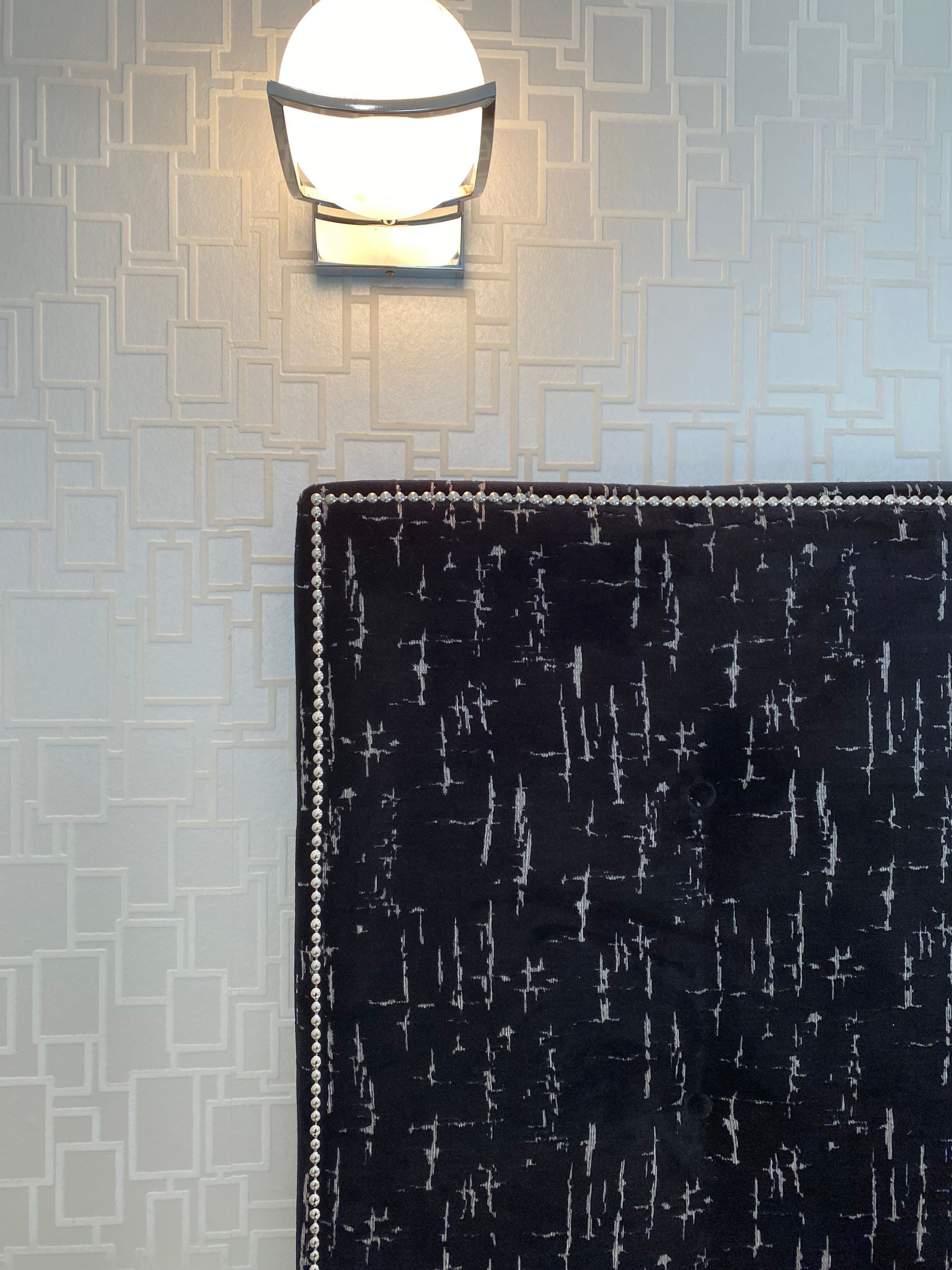 A wall with a lamp and a rug on it