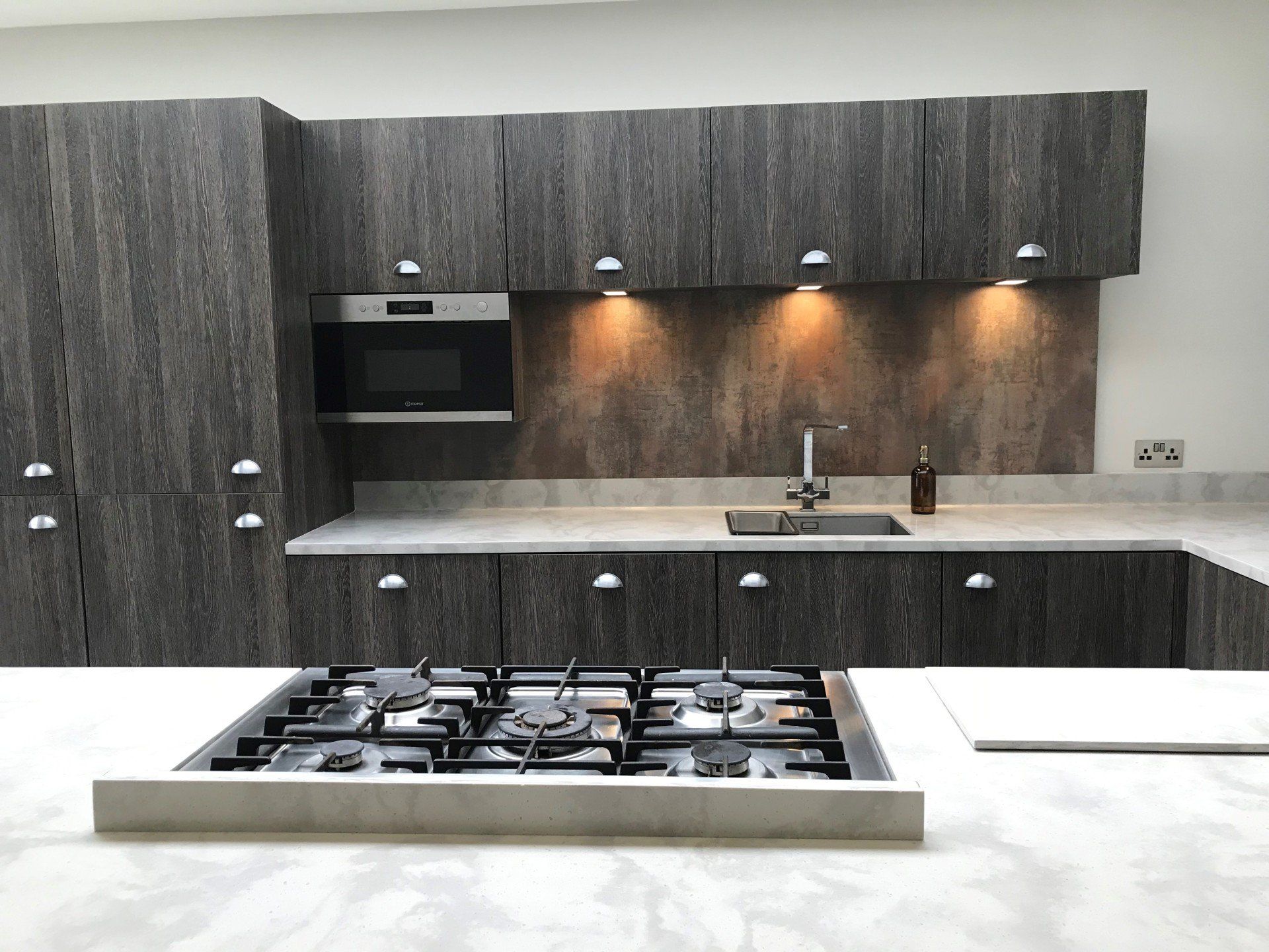 A kitchen with a stove top oven and a sink