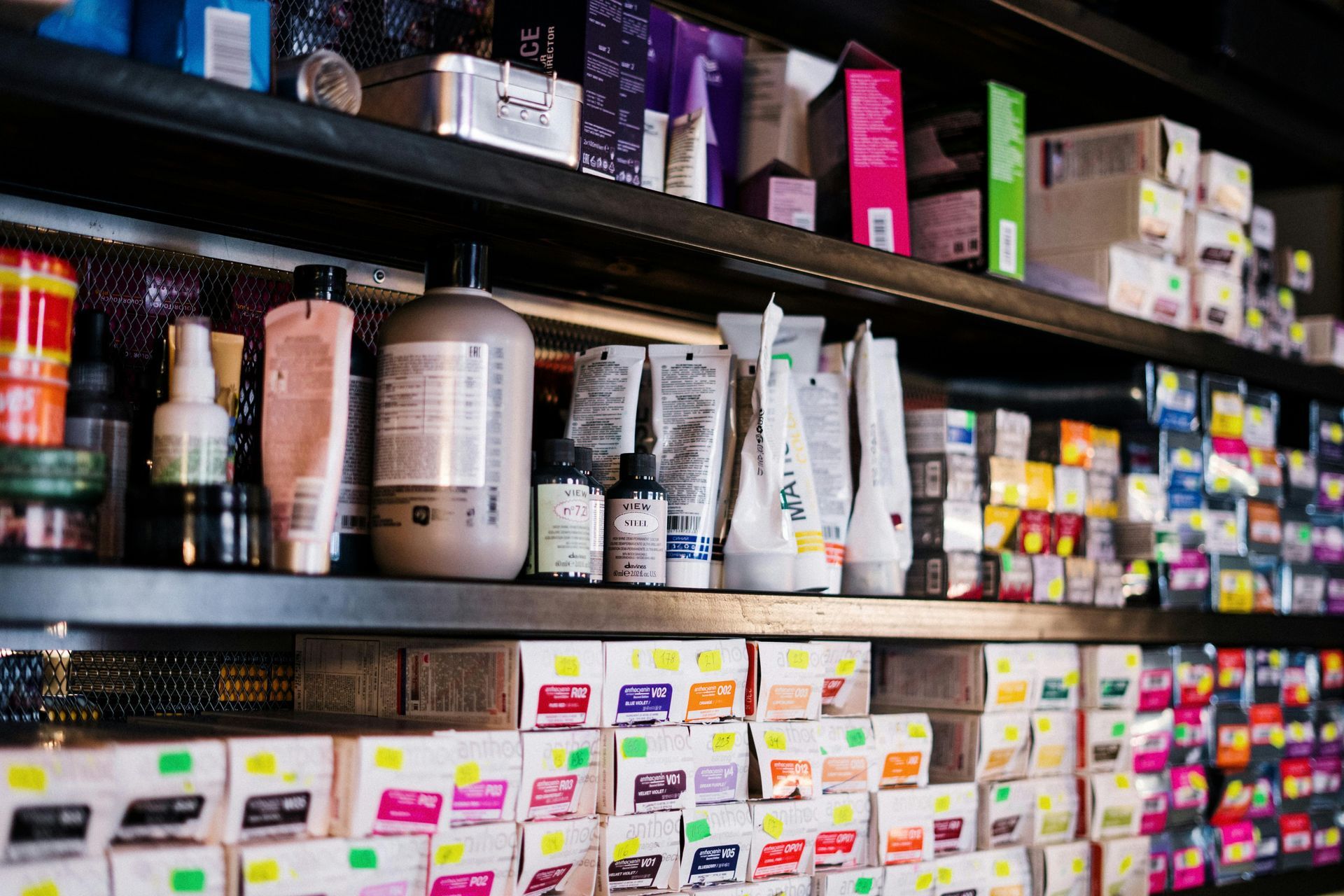 Shelves stocked with hair products and color boxes in a salon.