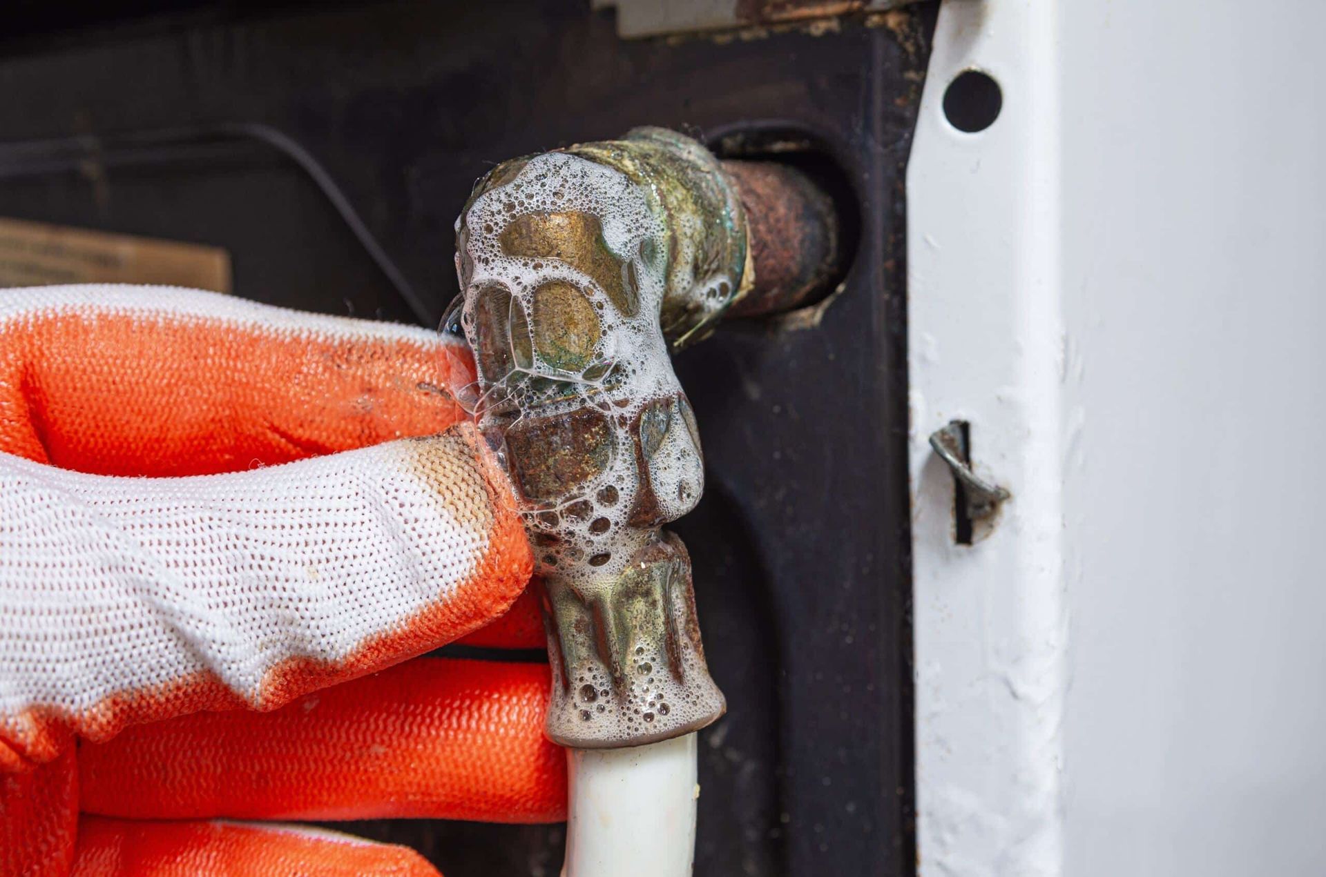 A Gloved Hand Testing a Brass Plumbing — Leak & Co in Zuccoli, NT 