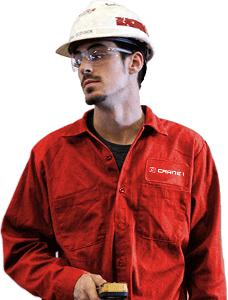 Man in red work uniform and hard hat, wearing safety glasses, holding a device.