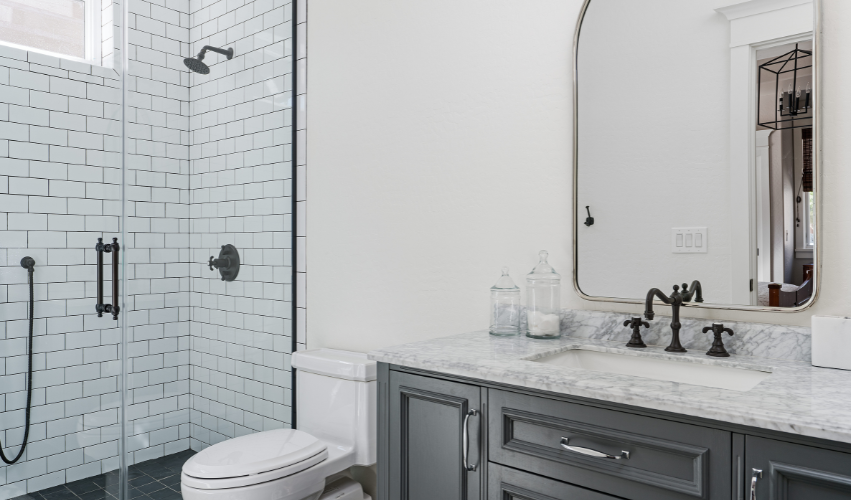 A bathroom with two sinks , a mirror and a walk in shower.
