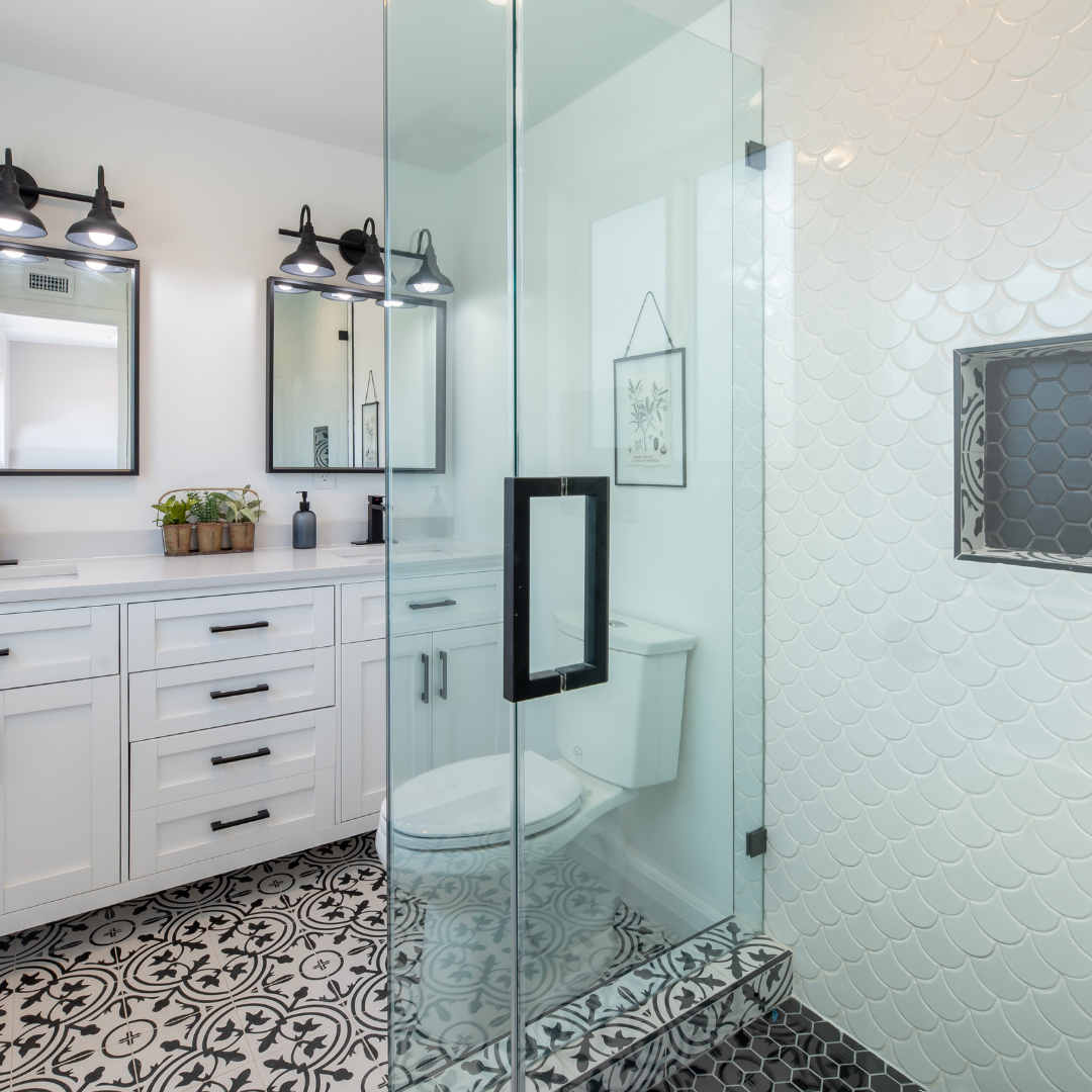 A bathroom with a toilet , sink , mirrors and a walk in shower.