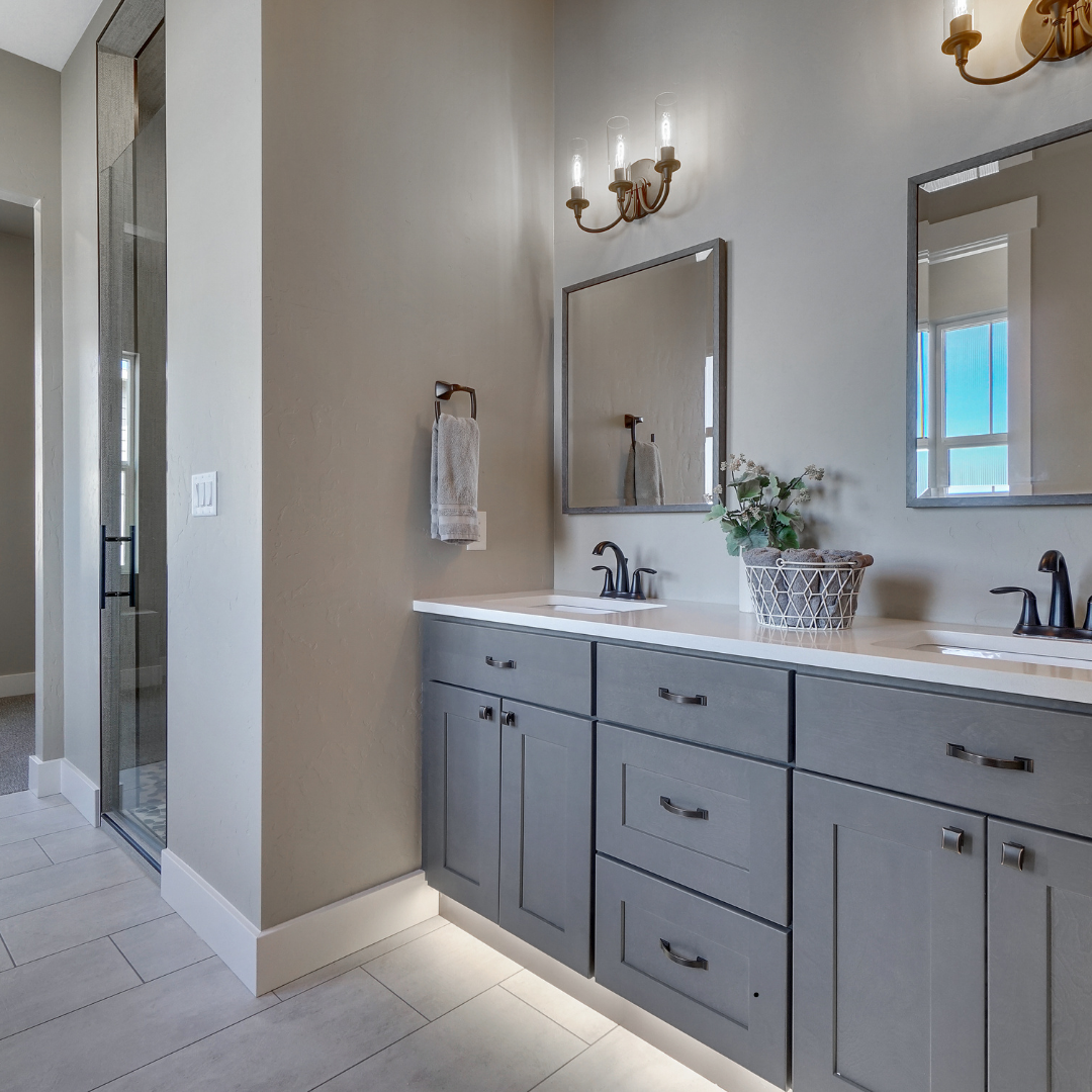 A bathroom with two sinks , a mirror , and a walk in shower.