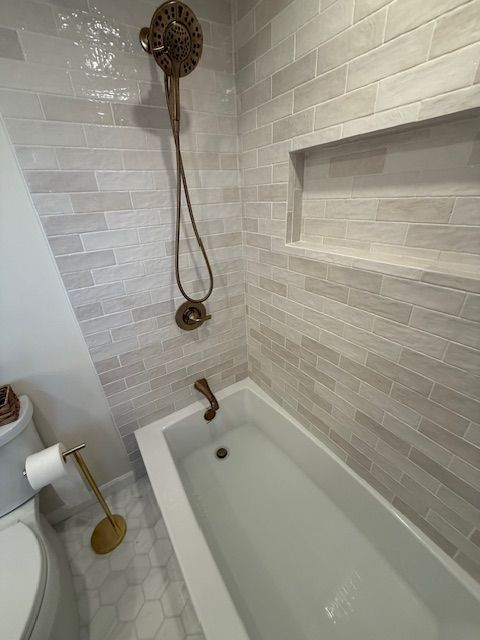 A bathroom with a bathtub , toilet and shower by Dan Kaplan owner of Reliable General Conttracting