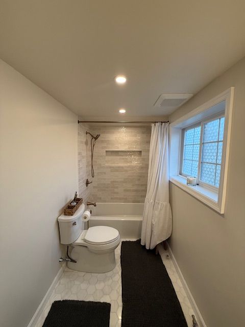 A bathroom in Collegeville, PA with a toilet a bathtub and a window