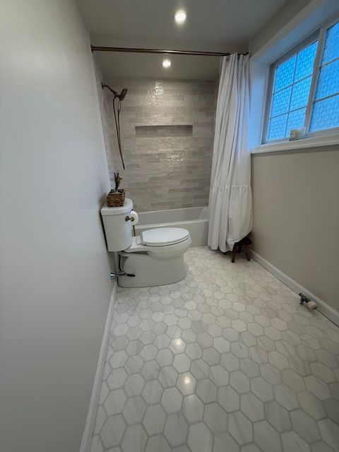 A bathroom with a toilet , shower and window by Reliable General Contracting HQ in Royersford, PA
