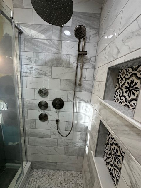 A bathroom renovation by Reliable General Contracting with a walk in shower and a shower head.