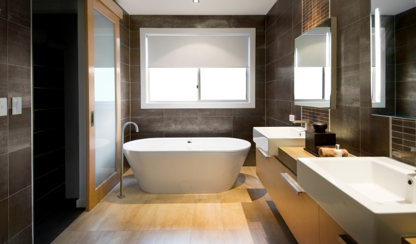 A bathroom with a toilet , sink , mirror and walk in shower.