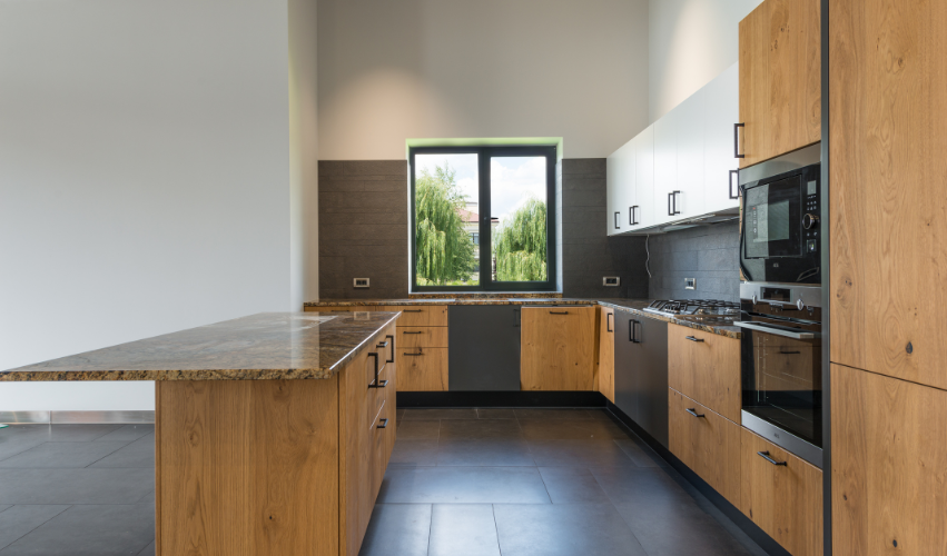 Modern kitchen with wooden cabinets, dark countertops, and a central island