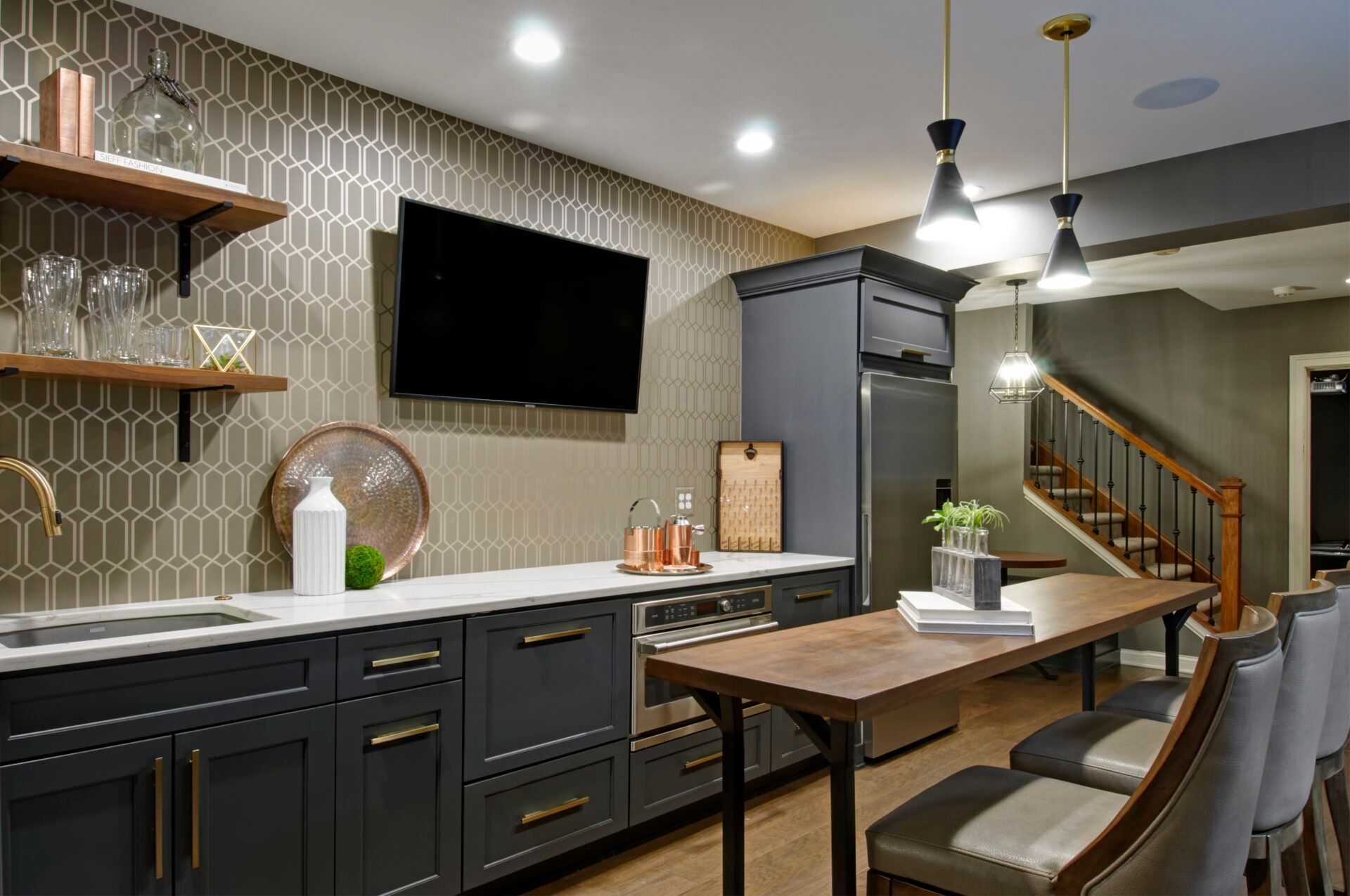 A kitchen with a table and chairs and a flat screen tv on the wall.
