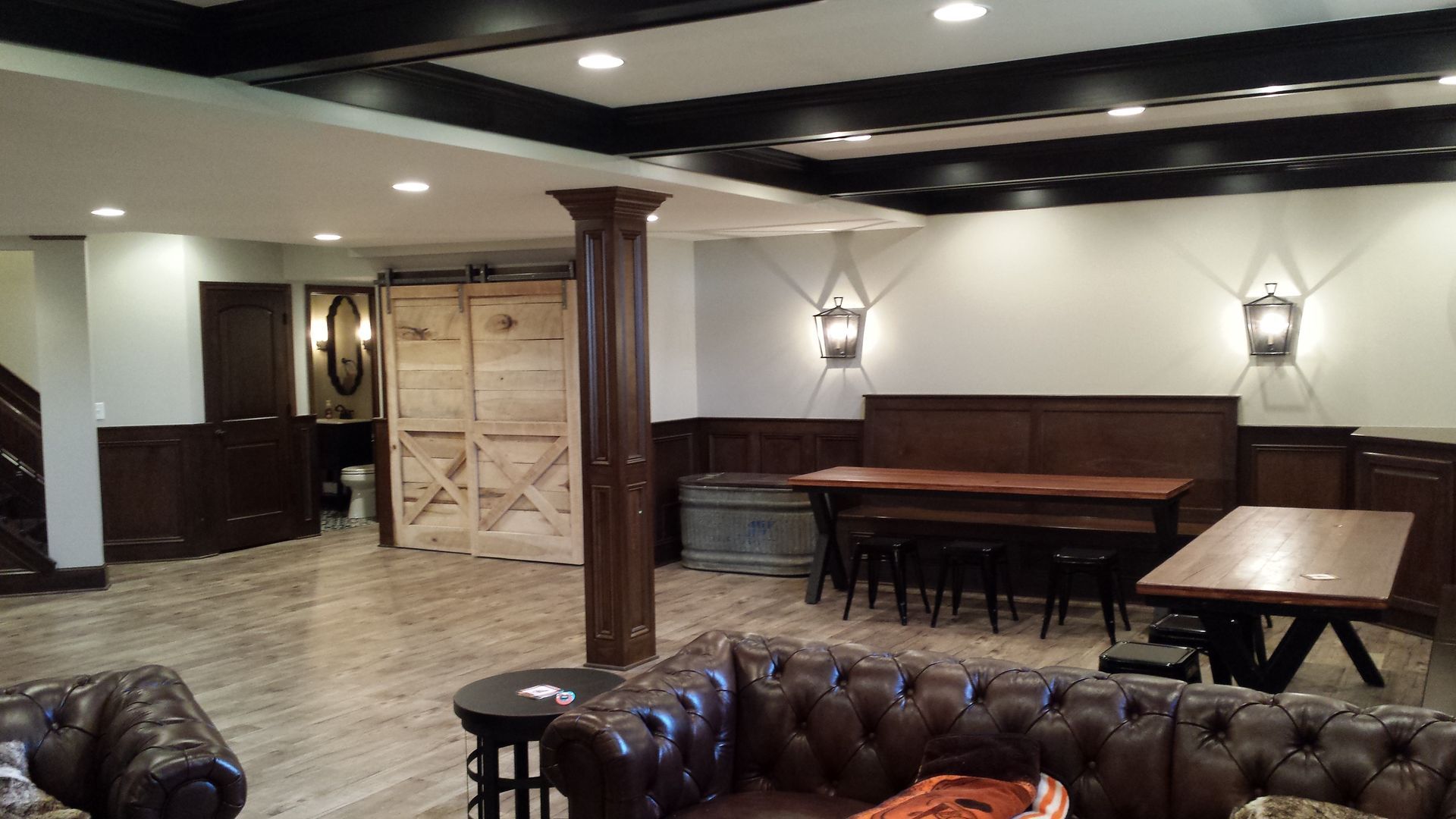 A living room with a couch , table and chairs in a basement.