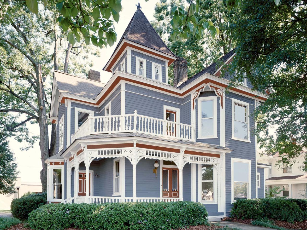 A large house with a porch and a tower on top