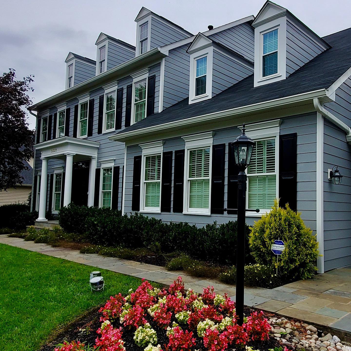 A large house with a lot of windows and black shutters