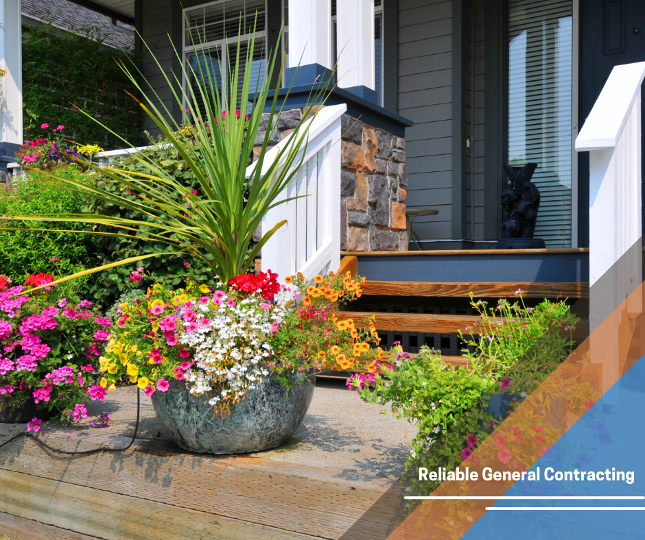 A potted plant with flowers in front of a house that says reliable general contracting