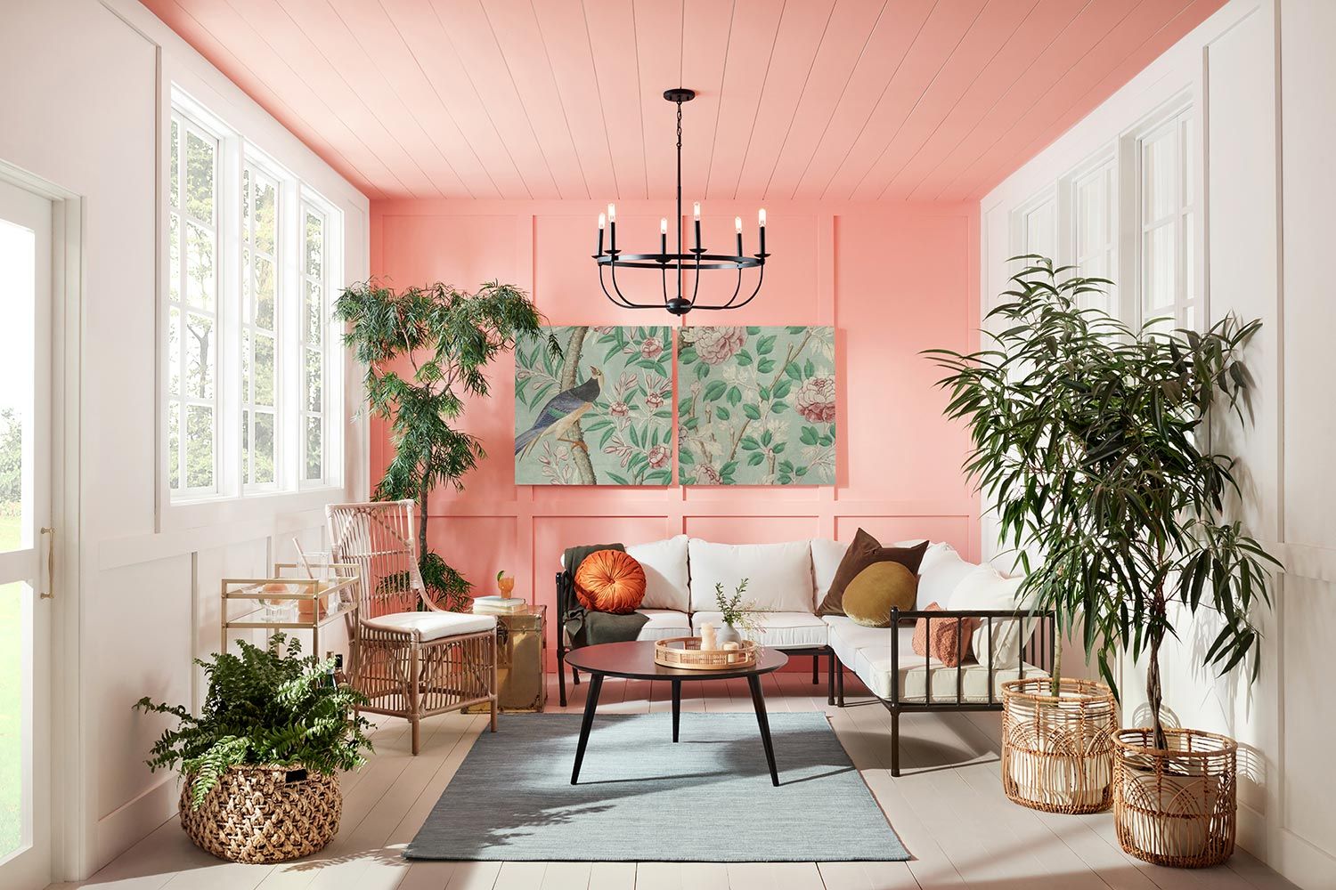 A living room with pink walls and a chandelier.