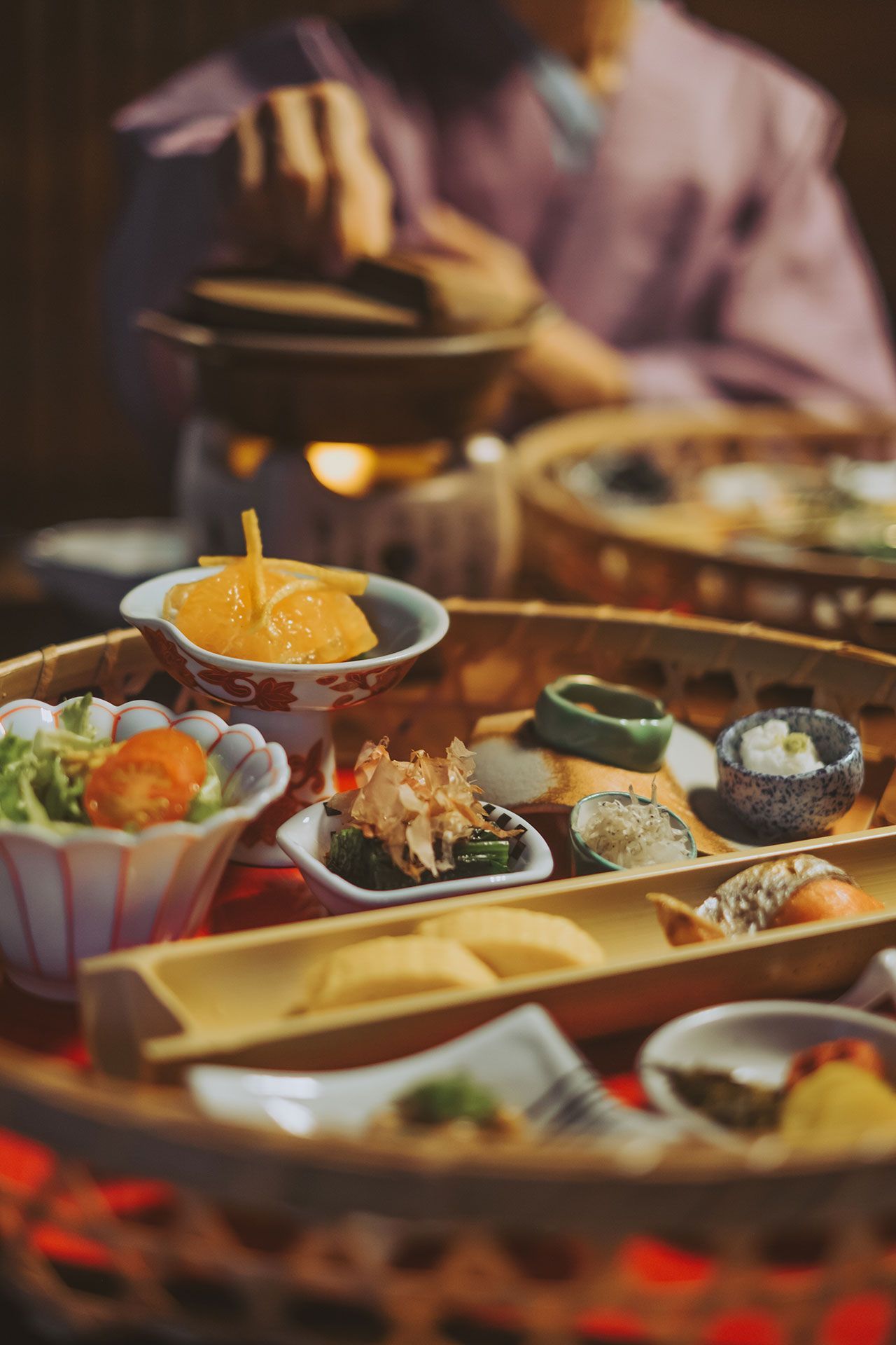 A person is sitting at a table eating food from a basket.