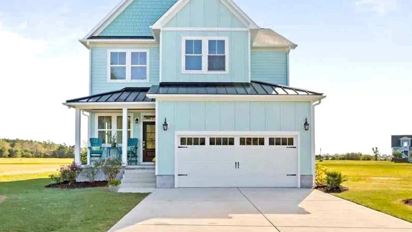 a finished exterior paint job of a light blue house with white trim located in Wilmington, NC