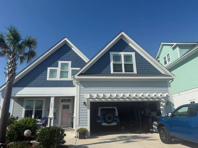 Blue and gray house with a garage and a blue truck parked in front.