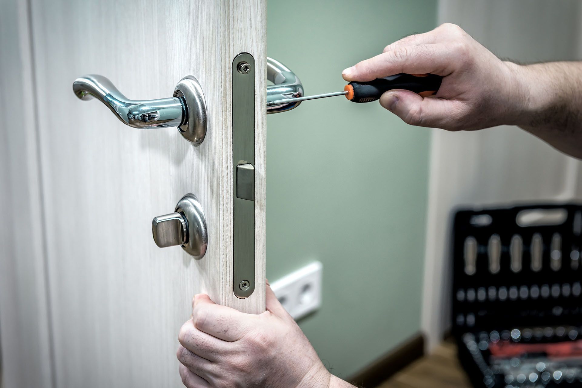 A person is fixing a door with a screwdriver