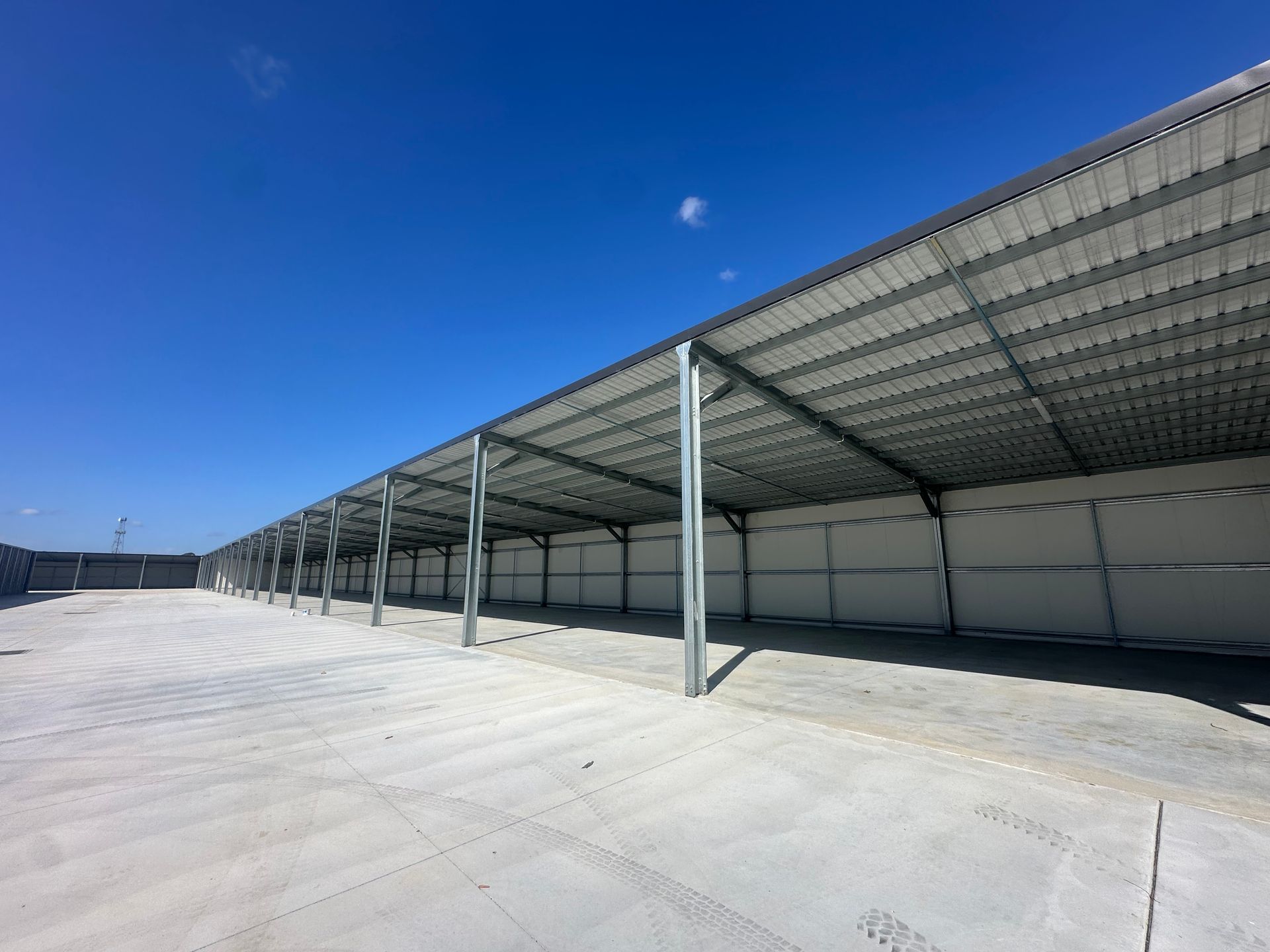 Empty Industrial Warehouse With Metal Roof, Concrete Floor, And Blue Sky — Midcoast Premium Caravan Storage in Forster, NSW