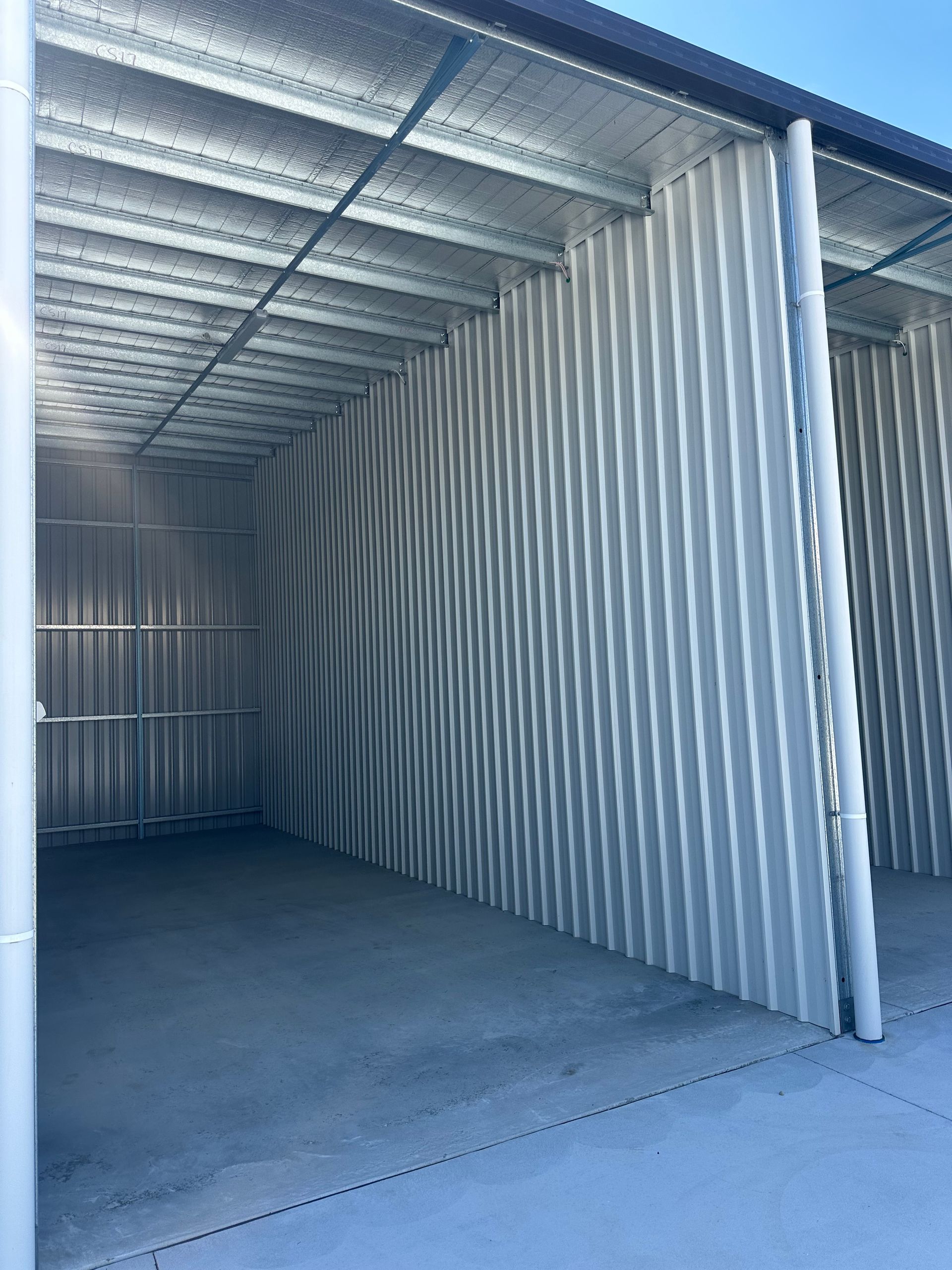 Empty Corrugated Metal Storage Unit With Open Front And Concrete Floor — Midcoast Premium Caravan Storage in Mid North Coast, NSW