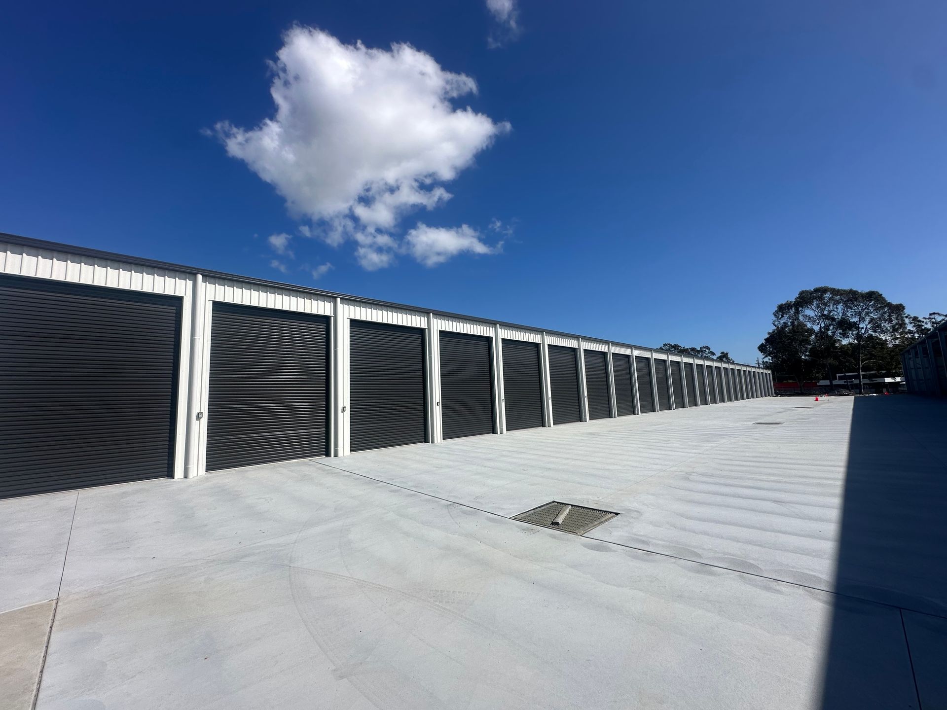 Rooftop With Black Solar Panels Along A Wall Under A Bright Blue Sky With One White Cloud — Midcoast Premium Caravan Storage in Forster, NSW