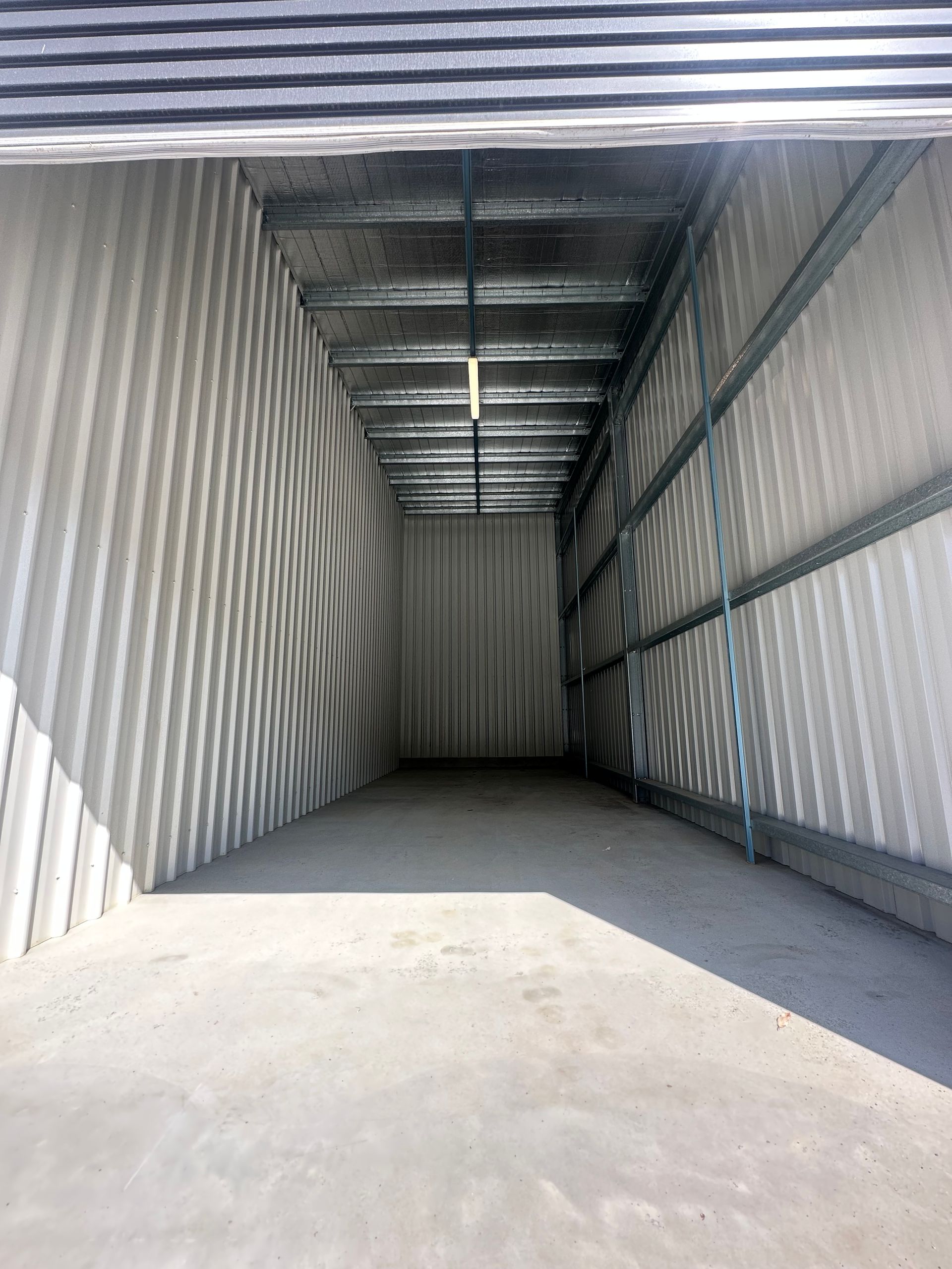 Empty Corrugated Metal Cargo Container With Sunlight On The Floor — Midcoast Premium Caravan Storage in Mid North Coast, NSW