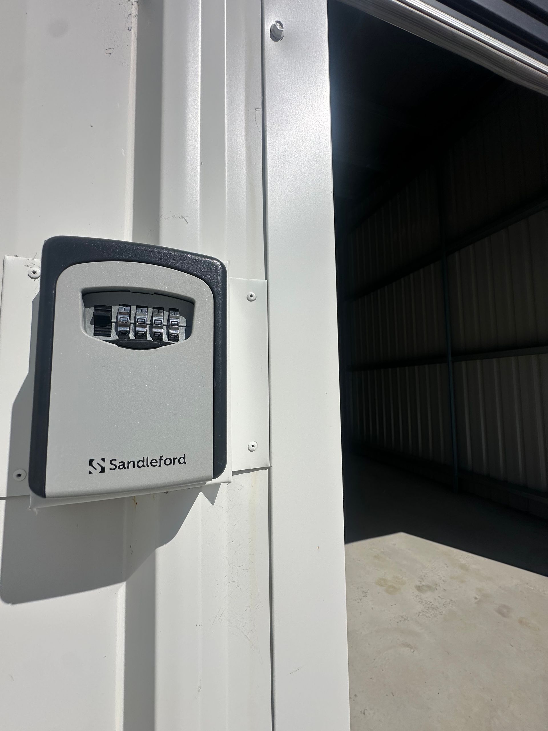 White Keypad/Access Panel Mounted On A White Wall Beside An Open Industrial Doorway — Midcoast Premium Caravan Storage in Forster, NSW