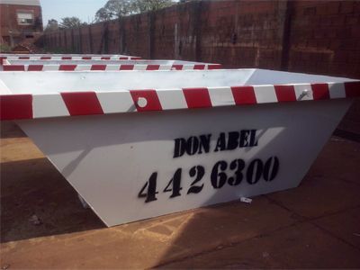 Contenedor industrial blanco con bordes a rayas rojas y blancas, etiquetado como 