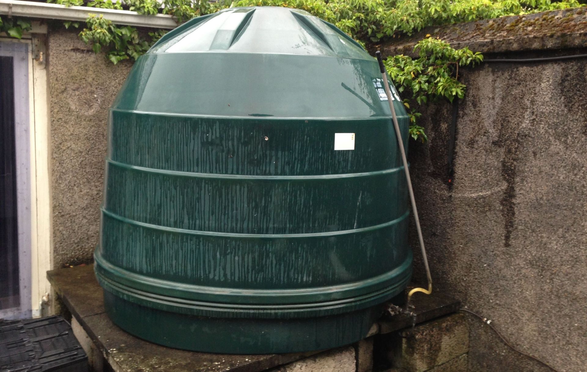 Photograph of a Titan 2,500 litres capacity oil tank with a defective sight gauge attached