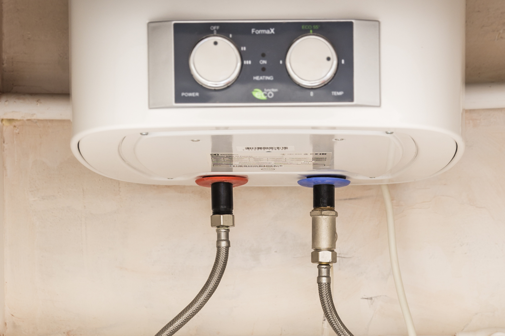 White electric water heater with dials and connected red/blue water lines.