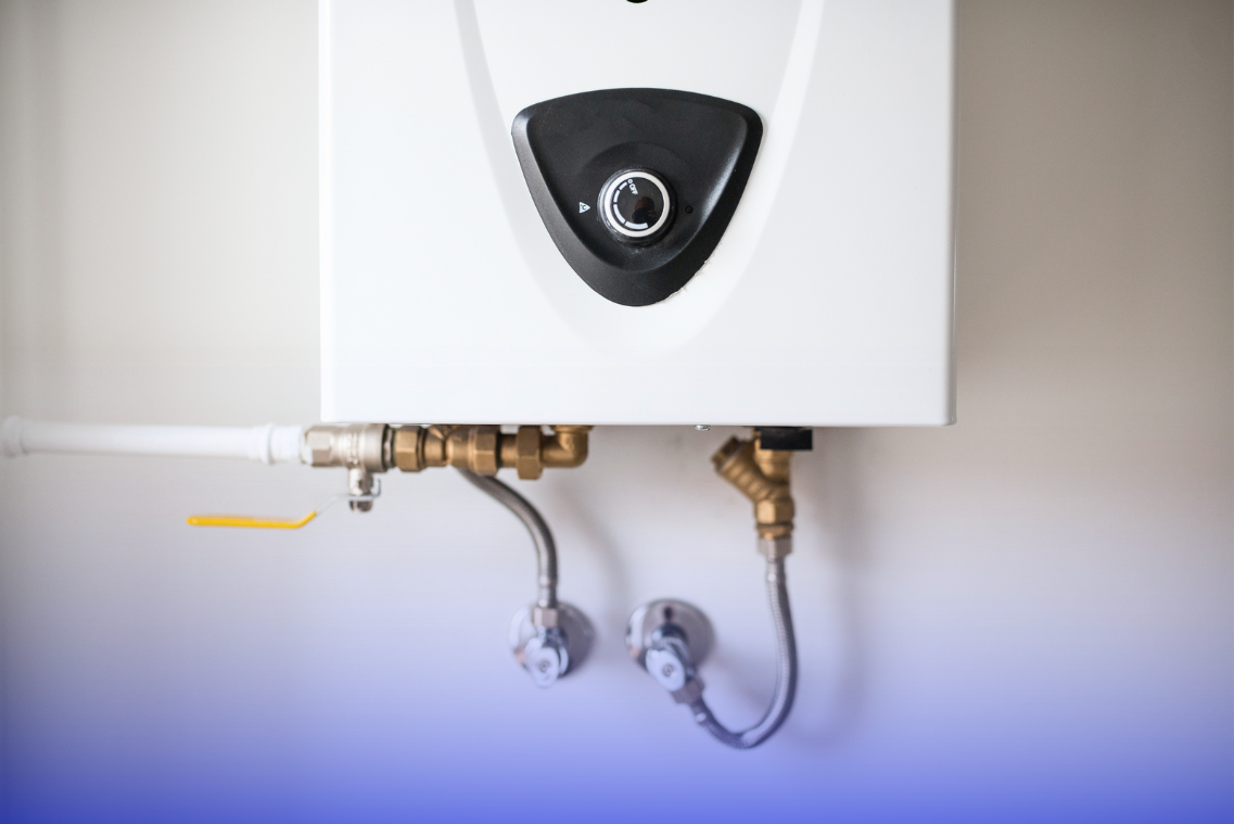 White water heater mounted on a wall with pipes and connections.