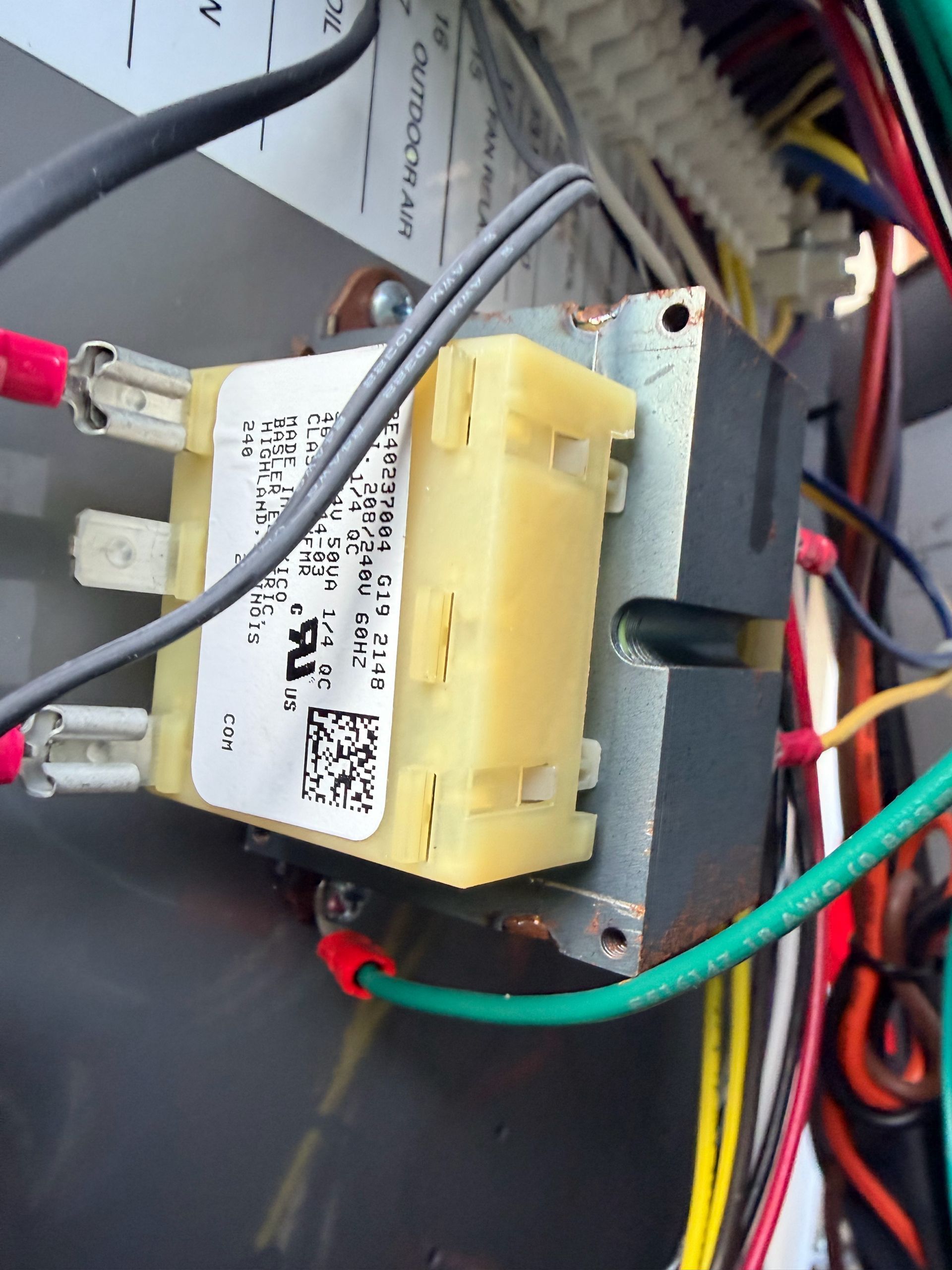Close-up of electrical wiring and a yellow connector block inside a device panel.