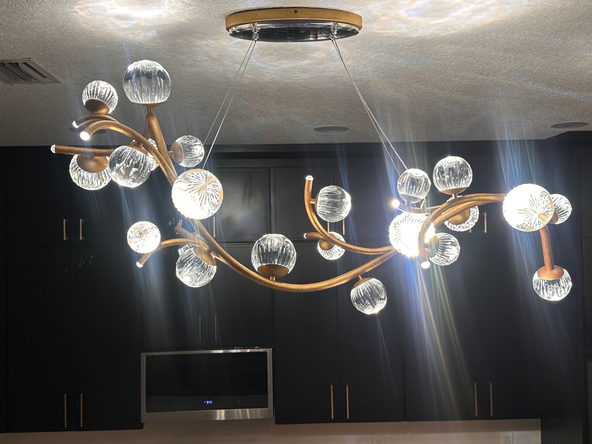 Modern chandelier with glowing glass spheres hanging in a dark room